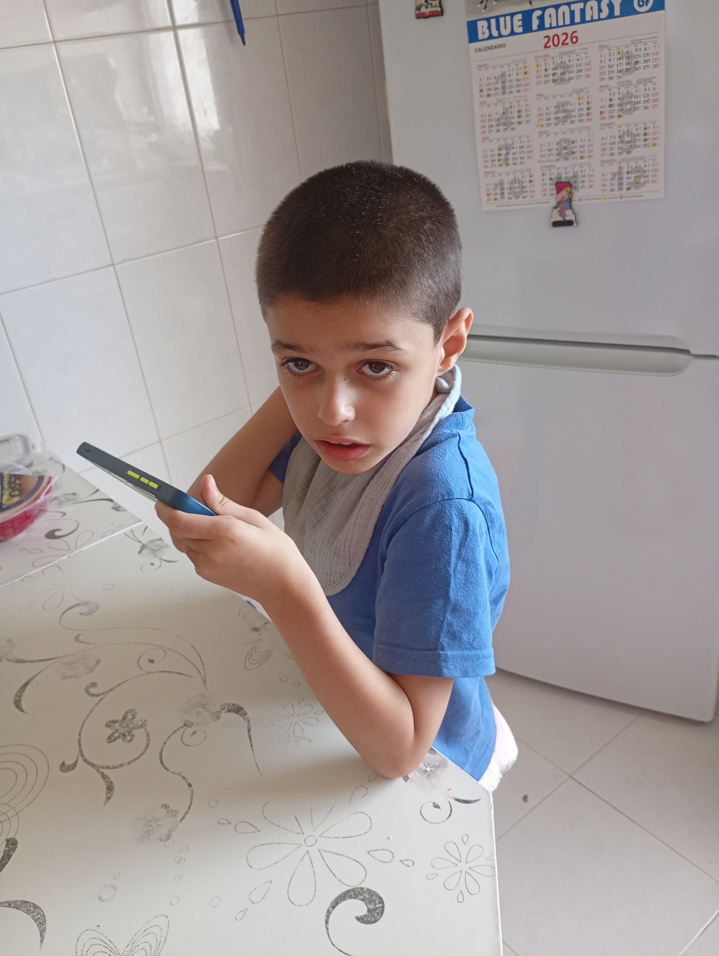 Bruno, um menino de 9 anos, sentado à mesa da cozinha