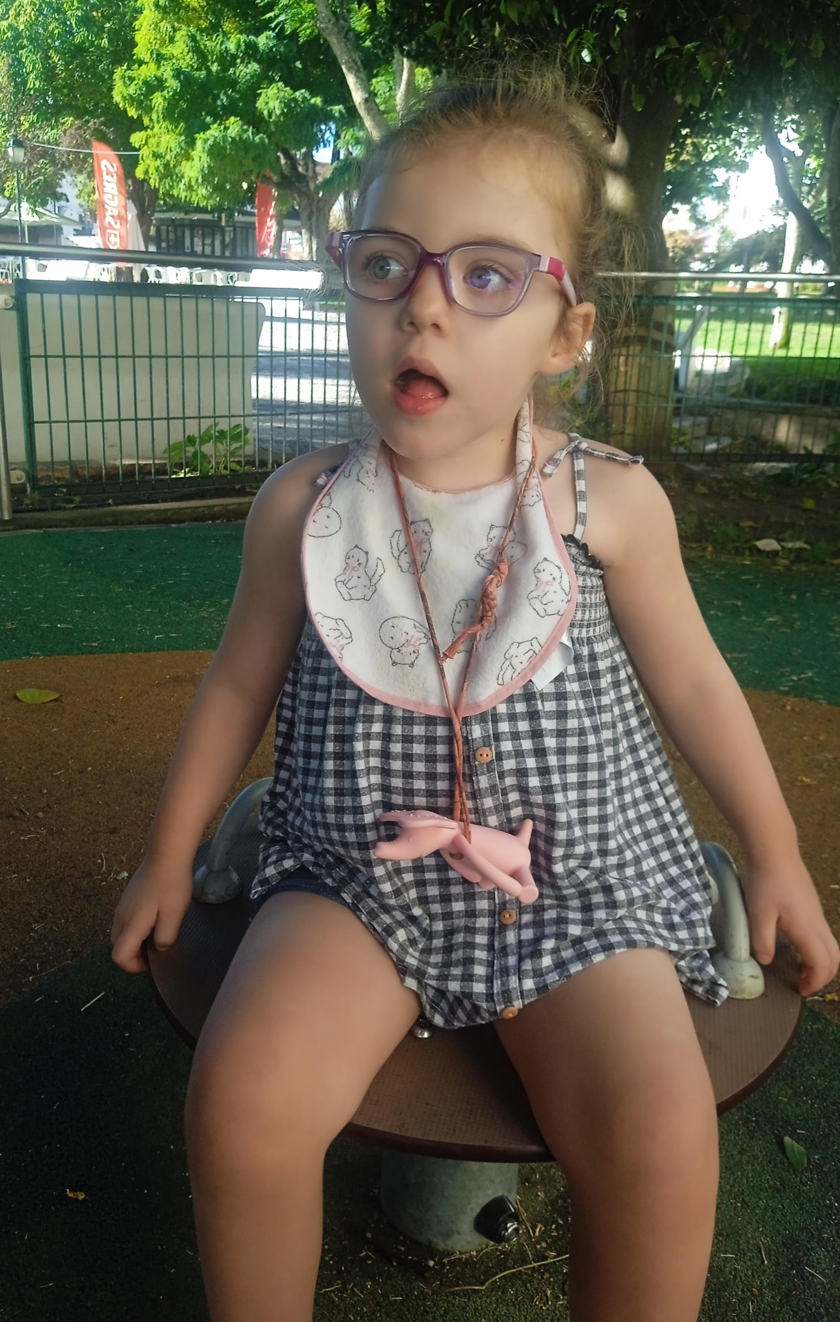 Fabiana, uma menina de 3 anos, sentada num baloiço no parque
